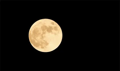 夜空中金色的满月，月面纹理清晰可见